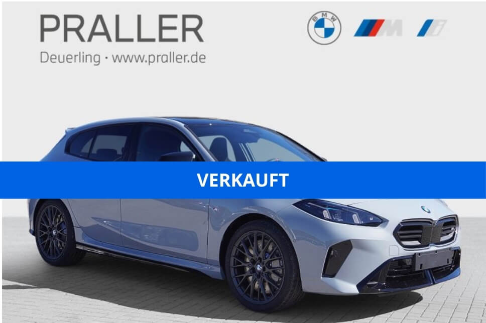 Ein hellgraues BMW-Fahrzeug ist vor einem Schild des Autohauses Praller geparkt. Ein blaues Banner quer über dem Bild zeigt "VERKAUFT" an und kennzeichnet das Auto als verkauft - entdecken Sie weitere BMW M Angebote bei der Autohaus Praller GmbH. - AH Praller